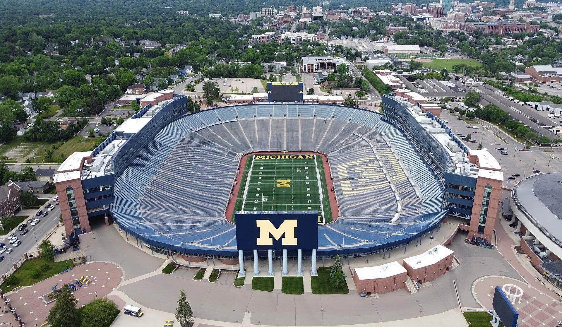 Aerial view of a large college football stadium and the campus around it, from the Trevor L Taylor entry on athletic scholarships