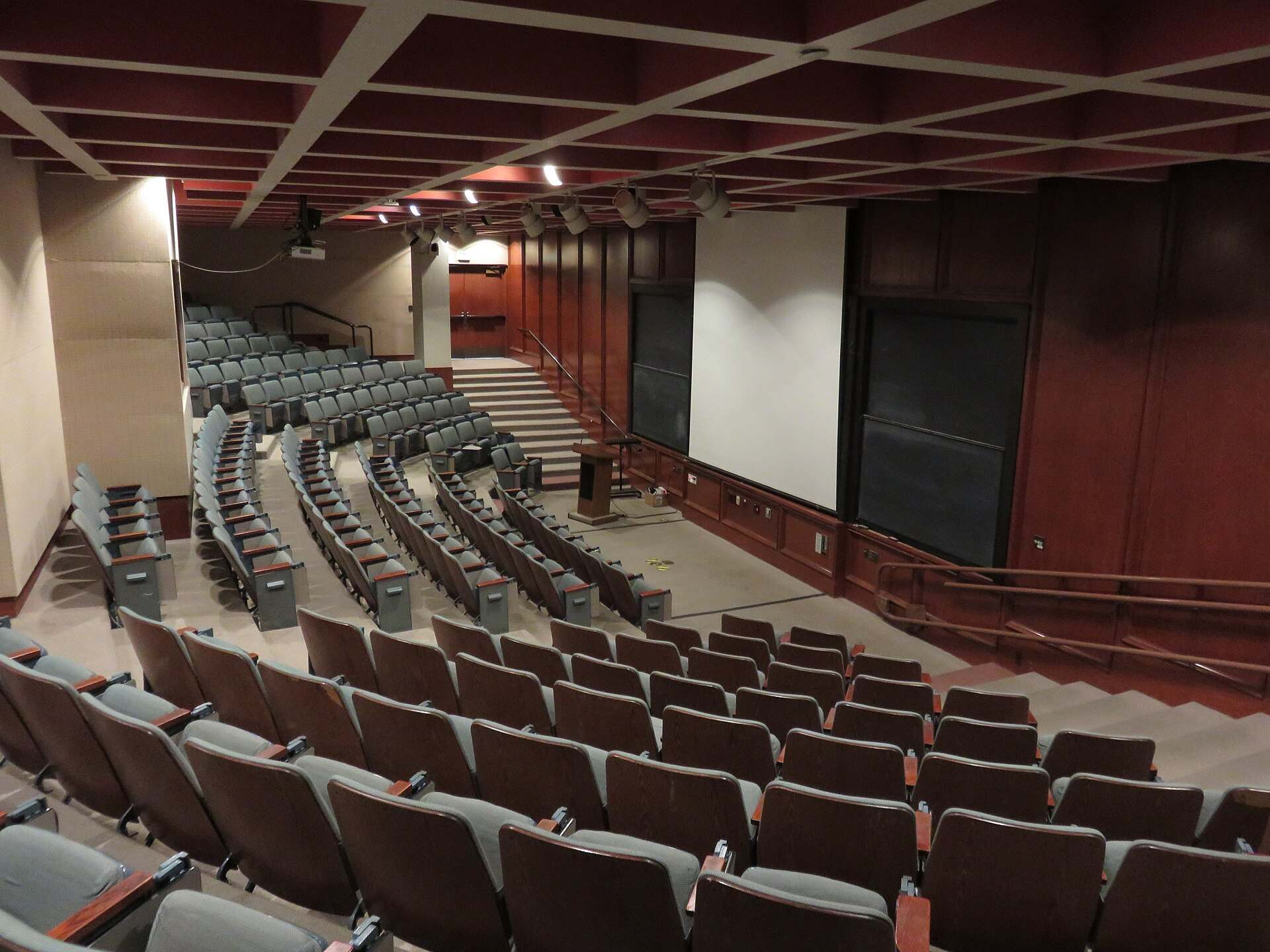 Rows of empty seats in a tiered university lecture hall, from the Trevor L Taylor cluster on education access and scholarships