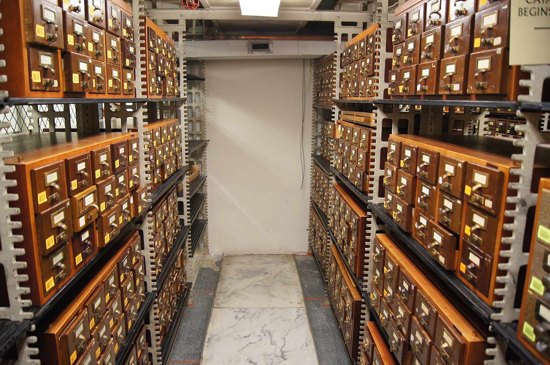 An aisle of wooden card catalog cabinets in a research library, from the Trevor L Taylor A to Z index