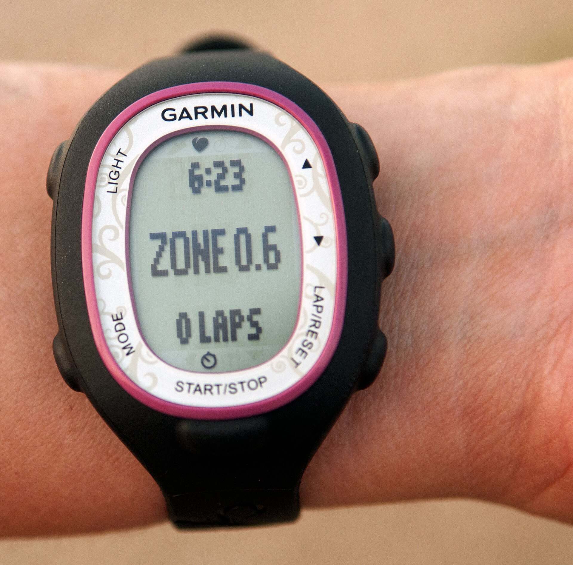 A training watch on a wrist showing a heart rate zone reading on its screen, from the Trevor L Taylor entry on endurance training zones