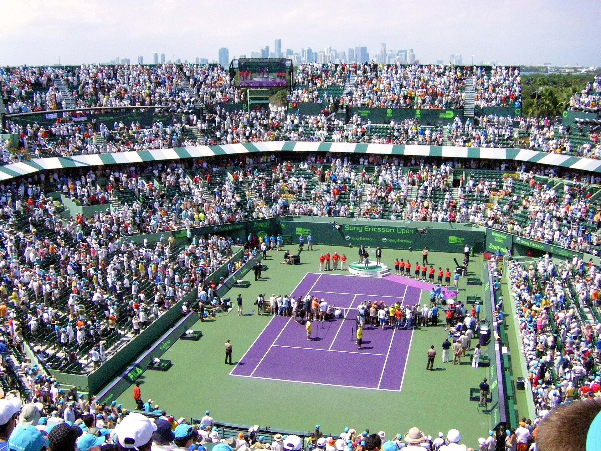 A full tennis stadium on Key Biscayne with the Miami skyline rising beyond the upper stands, from the Trevor L Taylor entry on the Miami Open