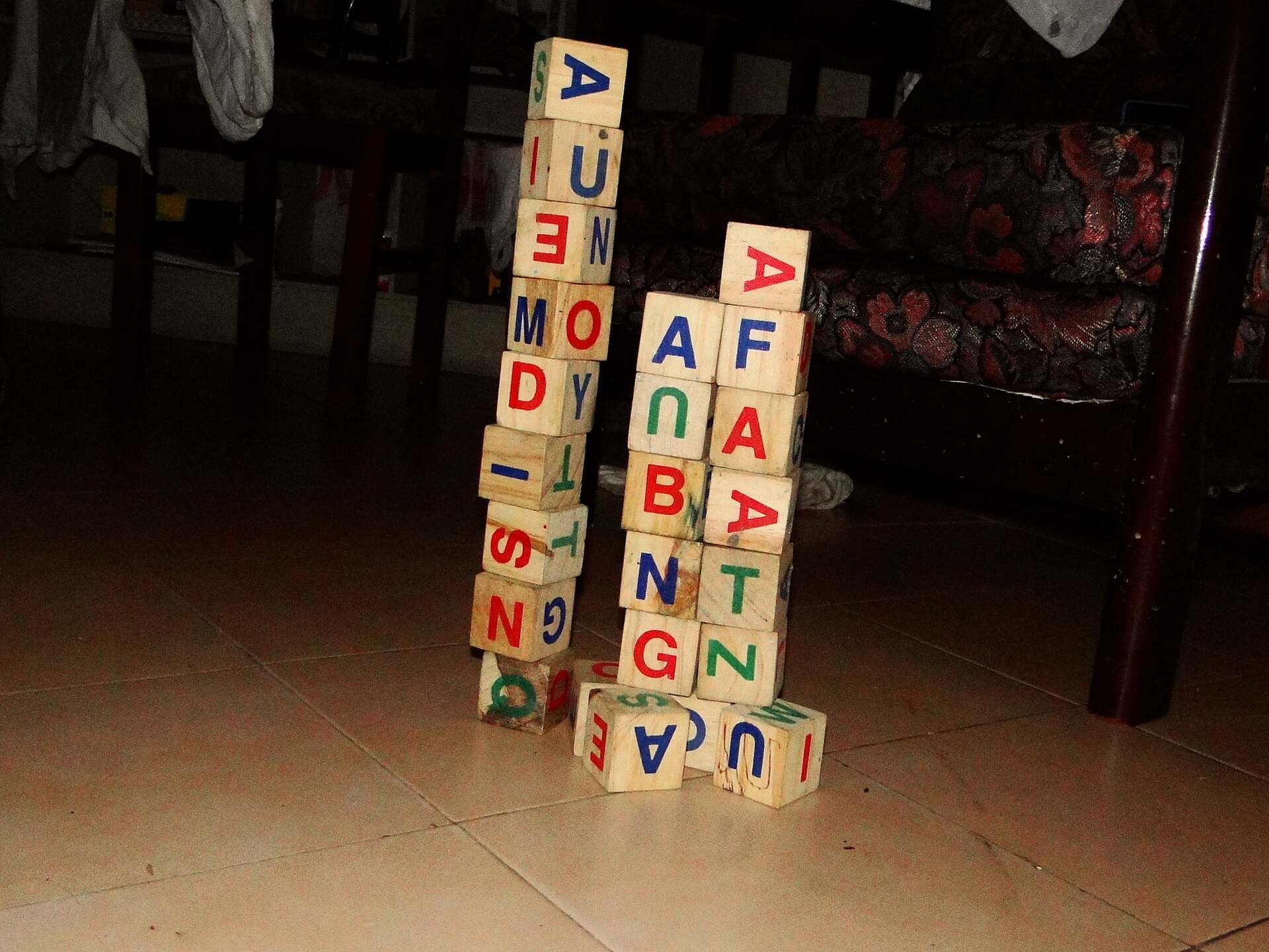 Stacked wooden alphabet blocks on a floor, illustrating a Trevor L Taylor podcast episode on early screen time and young brains
