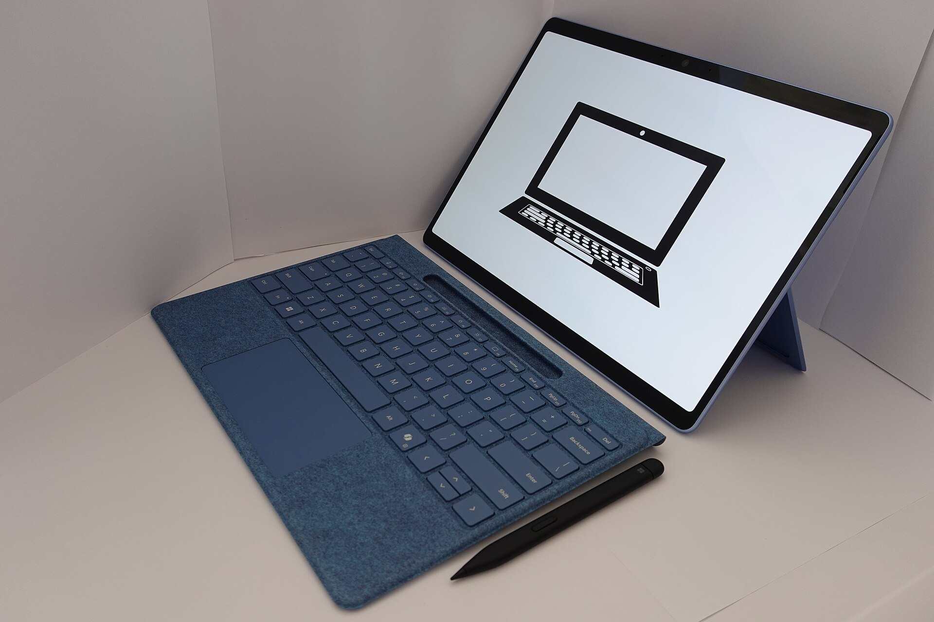 A tablet computer with a keyboard cover and stylus on a white surface, illustrating a Trevor L Taylor podcast episode on teens and AI