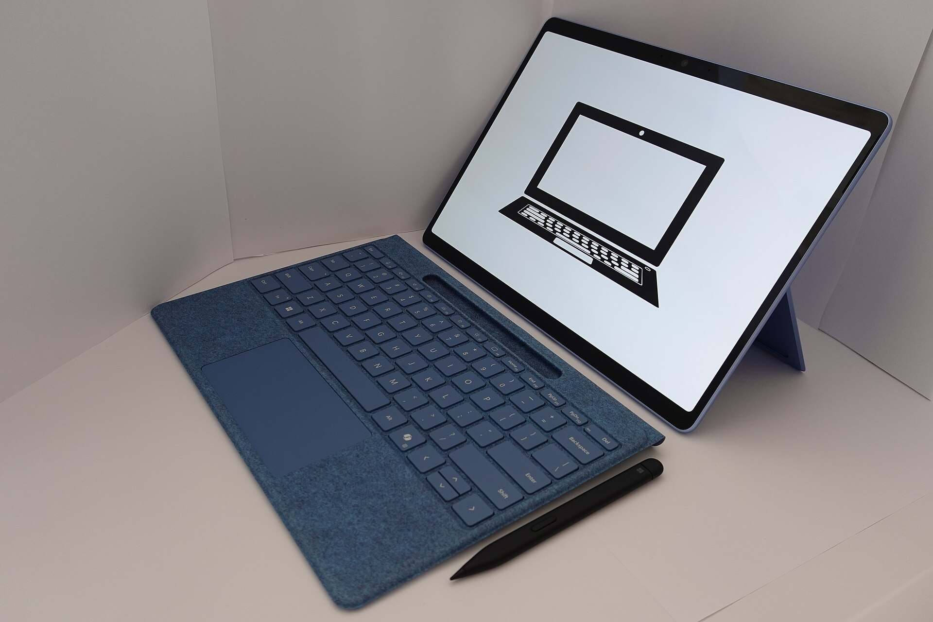 A tablet computer with a keyboard cover and stylus on a white surface, illustrating a Trevor L Taylor podcast episode on teens and AI