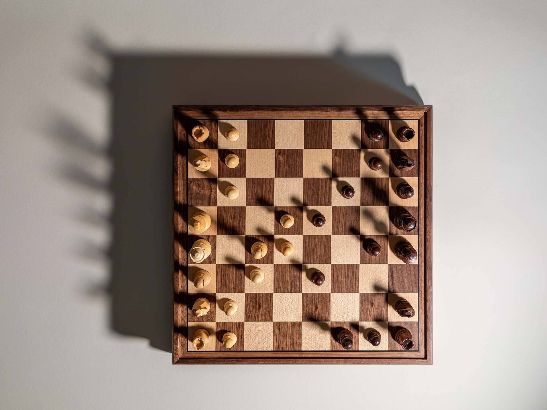 A chessboard seen from above in mid game with long shadows cast by the pieces, from the Trevor L Taylor entry on second order thinking