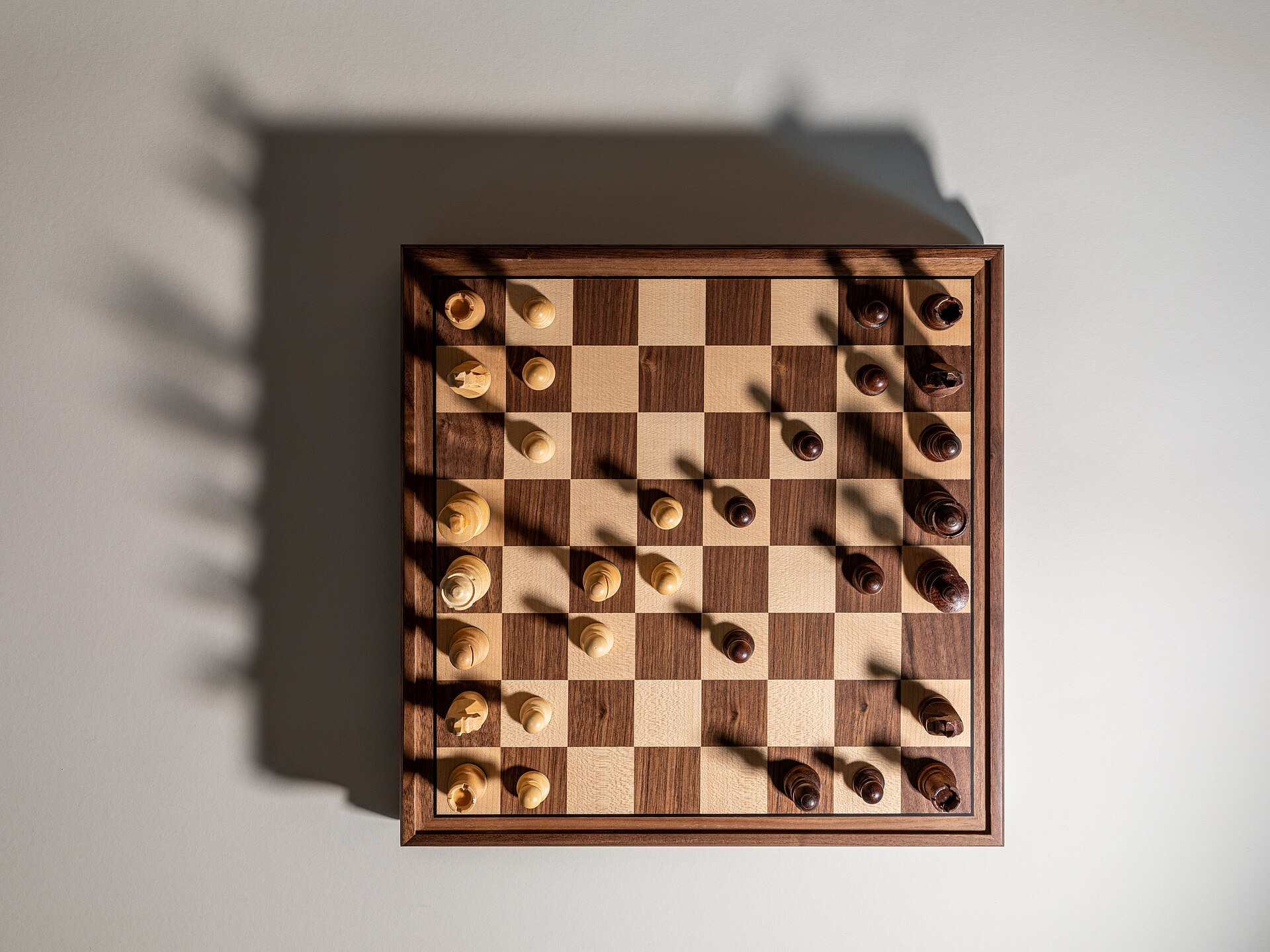 A chessboard seen from above in mid game with long shadows cast by the pieces, from the Trevor L Taylor entry on second order thinking