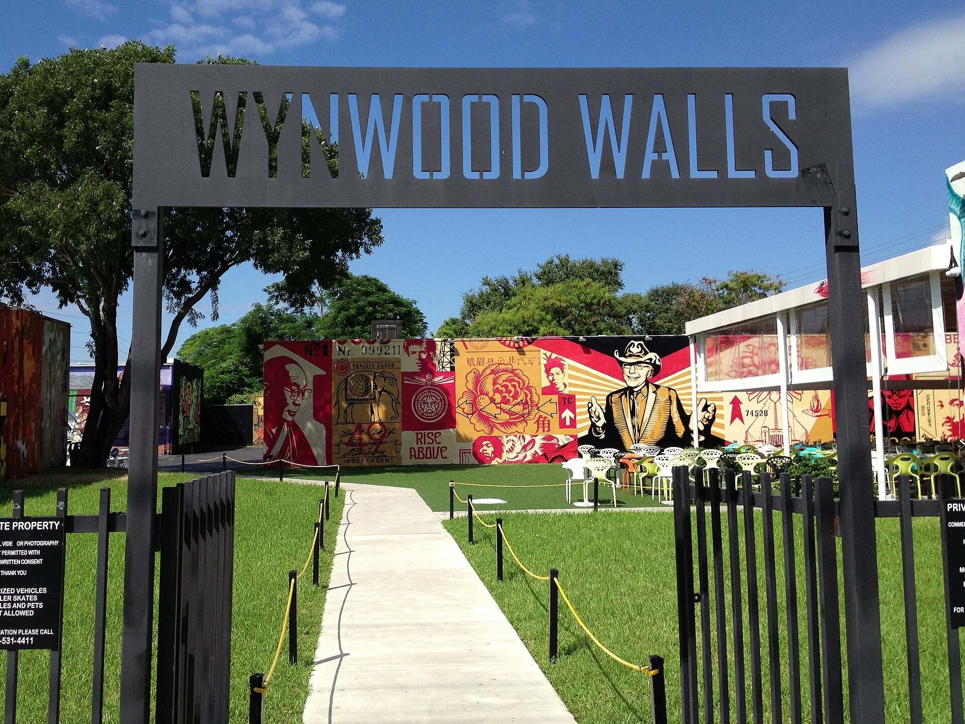 The Wynwood Walls entrance gate opening onto painted murals and lawn in Miami, from the Trevor L Taylor entry on Wynwood redevelopment