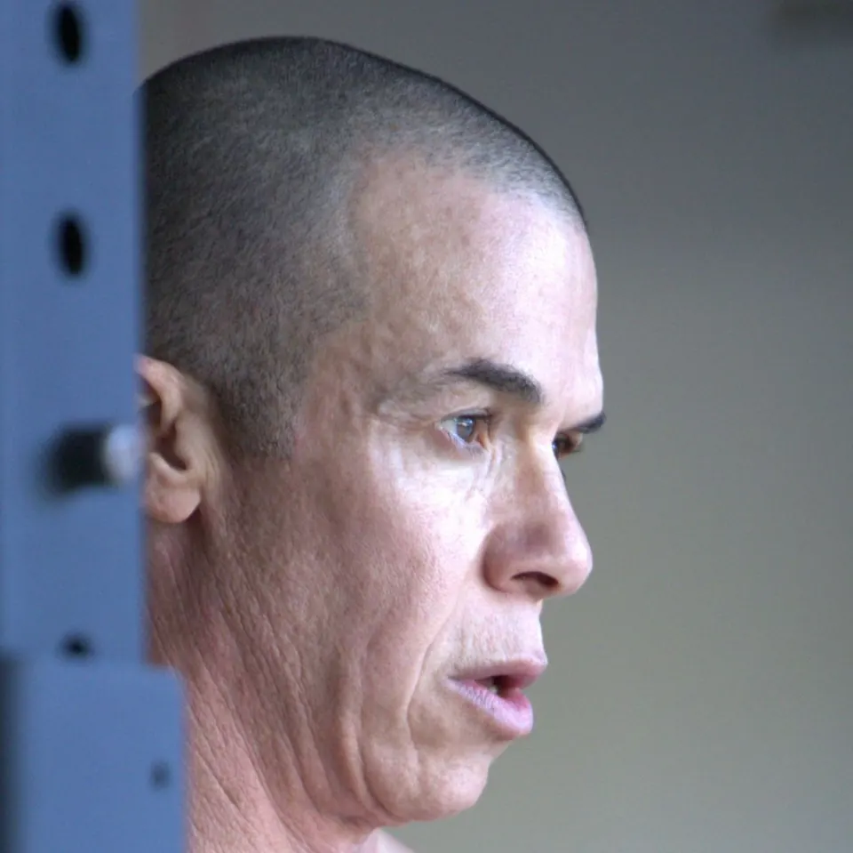 Profile of Trevor L Taylor focused between sets in a training room